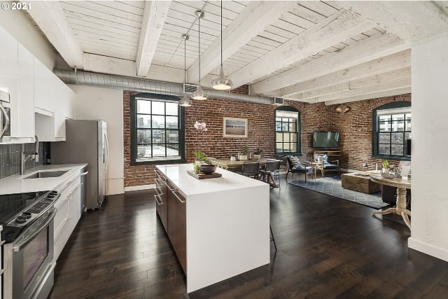 Modern loft living space with exposed brick walls and wooden beams